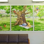 hand painted mural in Sauld Family center by Boulder Murals, family under tree, picnic by Boulder Murals